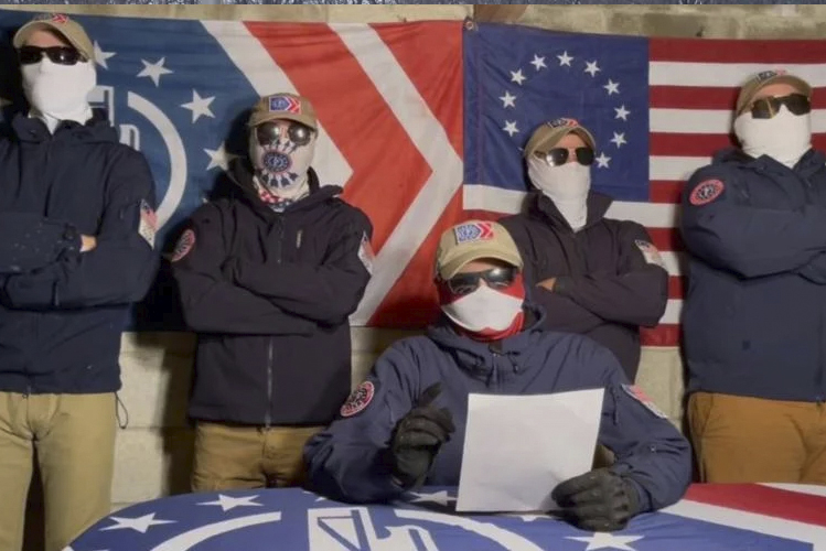 White supremacists standing in front of flags
